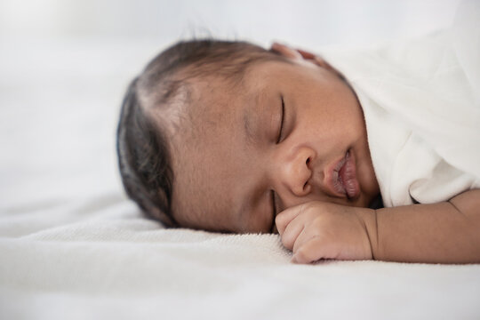 Portrait of close up black African American baby face sleep tight peaceful, hospital daycare nursery for new born baby. Love family healthcare and medical, mother or father's day, love tender concept