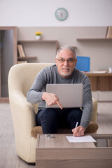 Old male employee working from home during pandemic