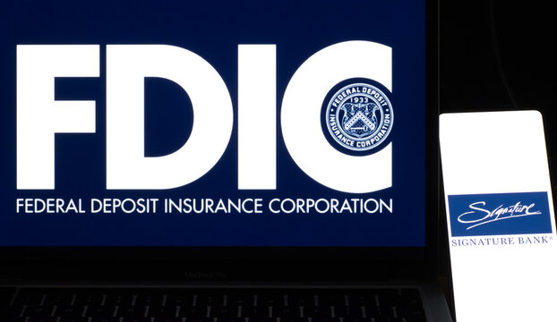 Smartphone with Signature Bank logo on background of FDIC ( Federal Deposit Insurance Corporation ) symbol, USA, March 13, 2023