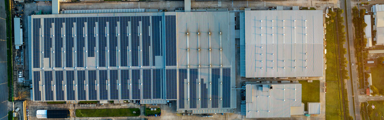 Obraz premium Top view Solar Panels on Warehouse Factory. Solar photo voltaic panels system power or Solar Cell on industrial building roof for producing green ecological electricity. Production of renewable energy