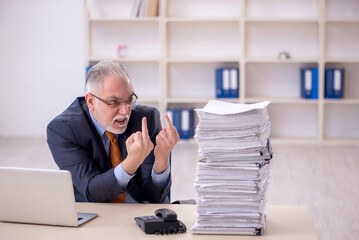 Old male employee unhappy with excessive work in the office