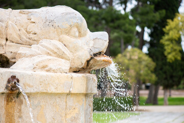 A stone fountain of a fish spit water as part of the Neptune statue in Parque Grande José Antonio Labordeta, Zaragoza, Spain.