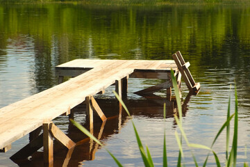 Fototapeta premium Old small Wooden Pier. No People. Beautiful Empty wood dock on River. Solitude, Loneliness concept. Reflections in water. Idyllic rural scene. Pastoral landscape. Ecological resort, fishing, swimming