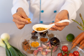 Beautiful close-up of chef hand in the kitchen manipulating ingredients to create new recipes. 