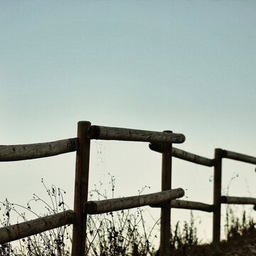 Wooden railing against clear sky during sunset