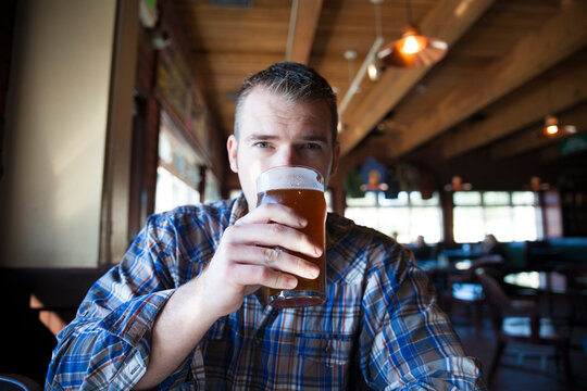 Portrait of man having beer while sitting in restaurant