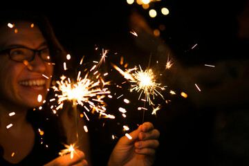 Happy woman holding sparklers