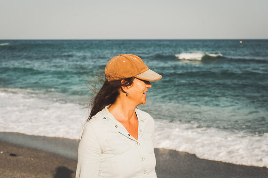 Woman looking away while standing on beach against clear sky
