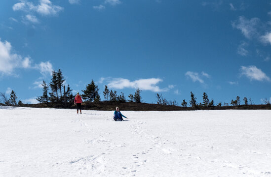 Hikers playing on snow covered field against sky