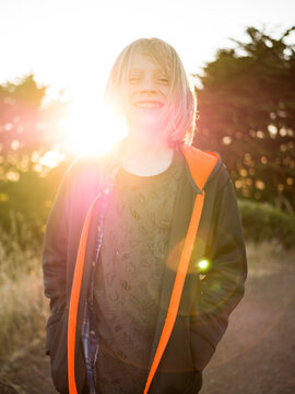Portrait of happy boy standing on field against clear sky