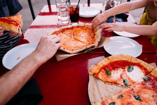 Cropped image of family having pizza at restaurant