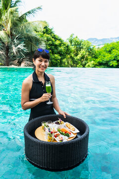 beautiful woman enjoys a floating breakfast in Thailand