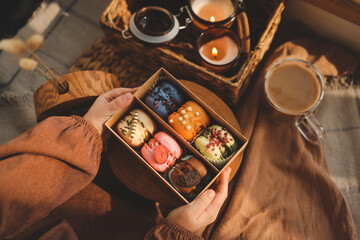 Box with different assortment of macaroons in hands