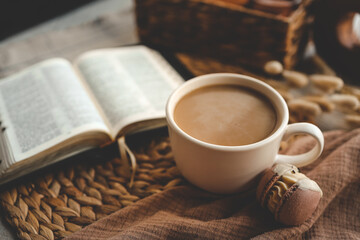 Coffee cup and macarons with an open Bible in the background