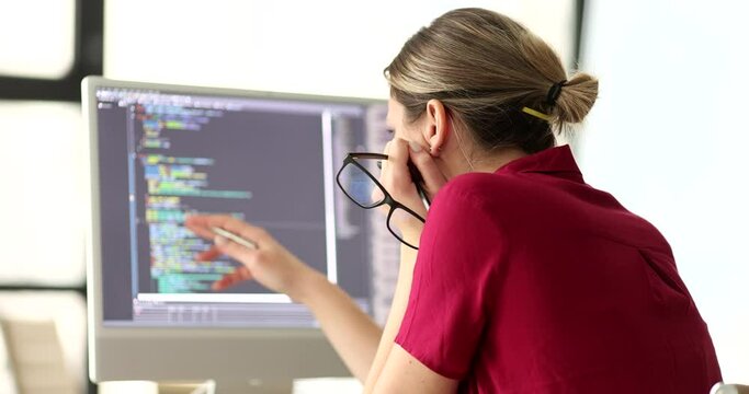 Woman programmer with glasses in hand studying information on computer screen 4k movie slow motion