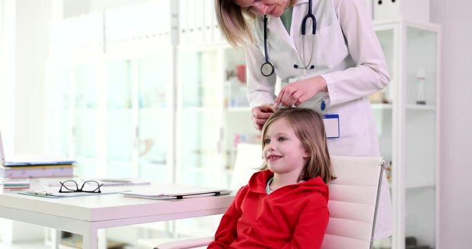 Doctor pediatrician examining head and hair of child in clinic 4k movie slow motion