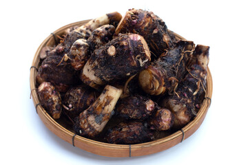 Organic taro fruit in bamboo weave plate on white background.
