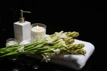 Fototapeten Healthy Concept, bunch of tuberose flower  ,oil bottle, towel, Spa with candle and stone  © Mee Ting