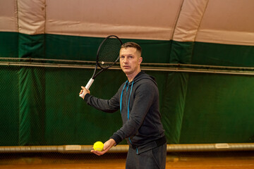 professional tennis player is hitting tennis on an indoor tennis court from early morning.