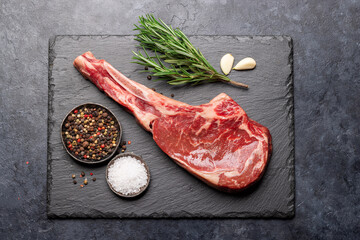 Raw Tomahawk beef steak and spices