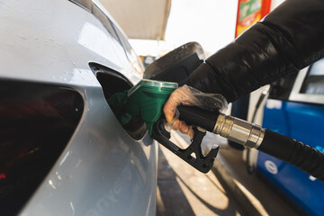 Closeup of man pumping gasoline fuel in car at the gas station, car concept. High quality photo - obrazy, fototapety, plakaty