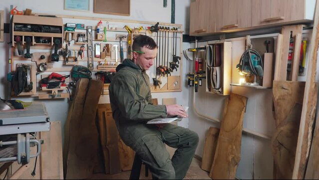 The repairman of wooden products thinks about the task and writes down thoughts