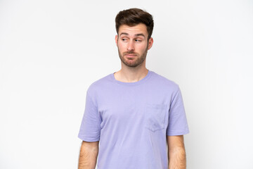Young caucasian man isolated on white background making doubts gesture looking side