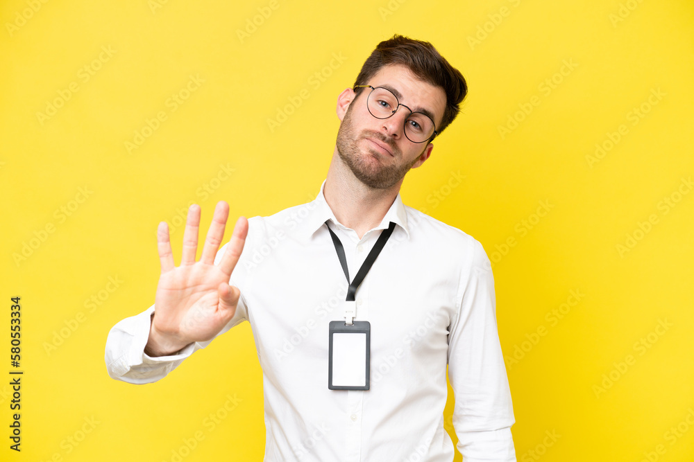 Poster Young caucasian with ID card isolated on yellow background happy and counting four with fingers