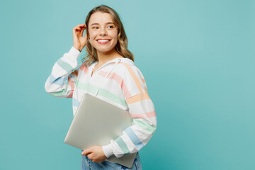 Side profile view smiling happy young IT woman wears striped hoody hold closed laptop pc computer...