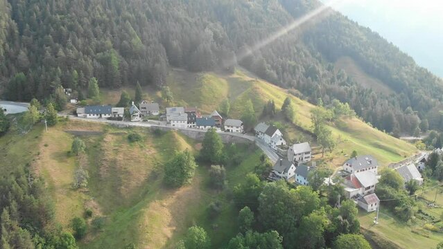 drone flies away from Strmec village in julian alps, triglav national park,