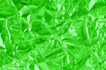 Shiny green lime foil texture background, pattern of wrapping paper with crumpled and wavy.