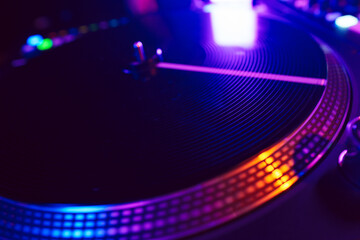 Close up of DJ mixing console in party light