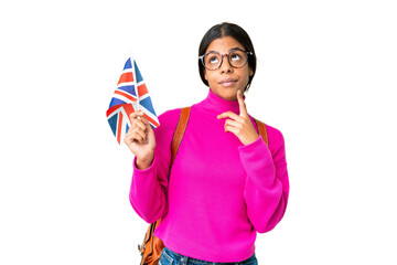 Young African American woman holding an United Kingdom flag over isolated chroma key background having doubts while looking up