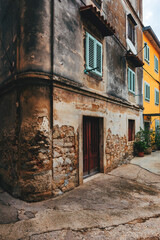 Old town of Lovran in Croatia, distinctive Istrian architecture with worn facades and wooden window shutters