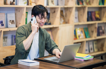 Fototapeta premium Young Asian man studying at library