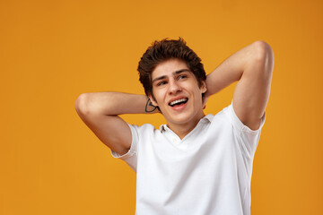 Portrait of a happy young casual man standing over yellow background