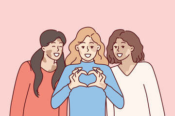 Three women with vitiligo syndrome are smiling demonstrating heart gesture as sign of self-love. Girl friends congratulate on vitiligo day calling for tolerance to people with depifmentation of skin