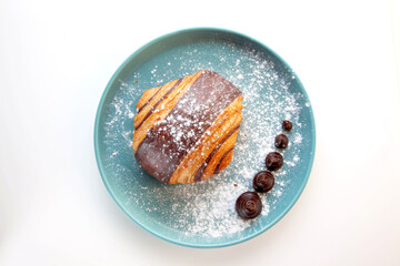 Brioche chocolate croissant served on a blue plate.
