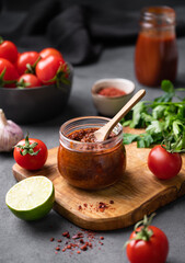 Spicy tomato sauce with red pepper, garlic and herbs on a dark background. The concept of traditional Italian cuisine.