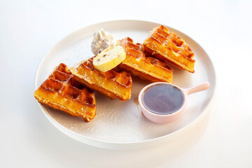 Waffle breakfast with honey butter whipped cream and maple syrup.