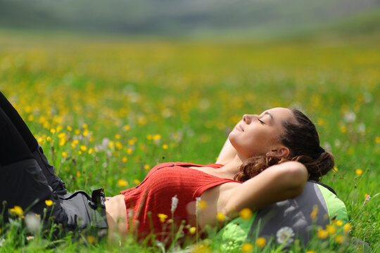 Backpacker relaxing lying on the grass in nature