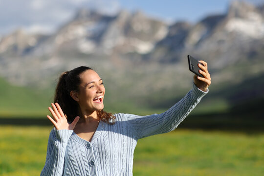 Happy tourist in nature having video call