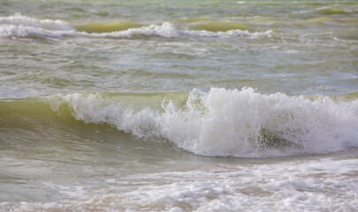 Fototapeta na wymiar White waves crashing water surface in stormy water weather
