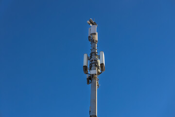 Fototapeta na wymiar Close up of antenna repeater tower on blue sky