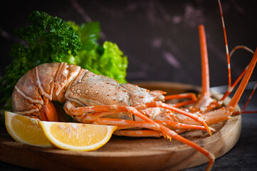 spiny lobster seafood on wooden plate, fresh lobster or rock lobster with herb and spices lemon...