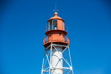 Old vintage structure lighthouse during the day on the blue sky background