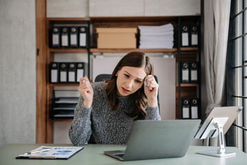 Bsiness woman is stressed, bored, and overthinking from working on a tablet at the modern office.