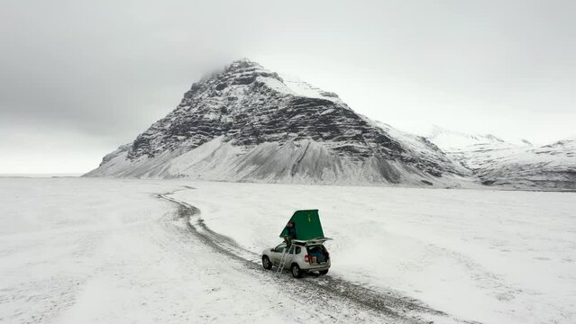 Beautiful campervan pitch with a completely snow-covered Iceland with a mountain peak in the background