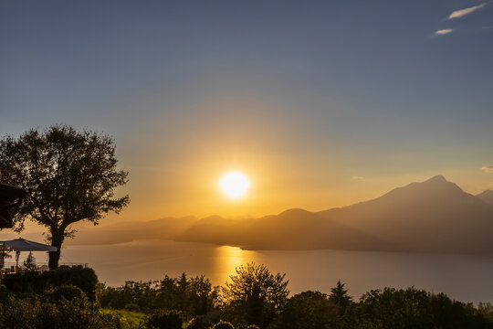 Italy, Veneto, San Zeno di Montagna, Lake Garda at sunset with Monte Pizzocolo in background