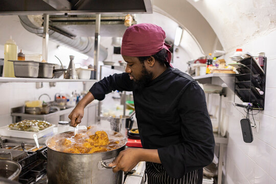 Chef stirring food in kitchen at restaurant